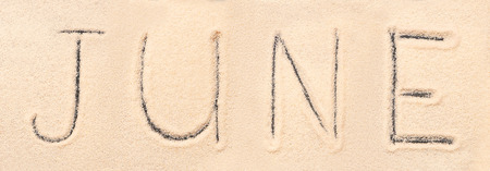 June lettering drawn on sand. Summer beach backgroundの写真素材