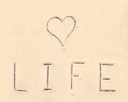 Love life lettering drawn on sand. Summer beach backgroundの写真素材