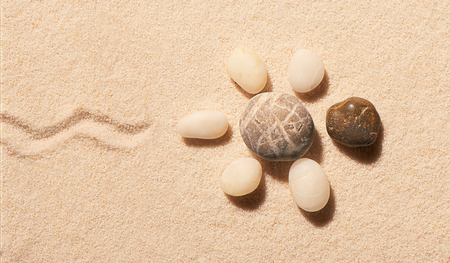 Turtle made of sea stones with mark of tail on sand. Summer beach background. View from aboveの写真素材