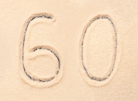60 number written on sand. Summer beach background
