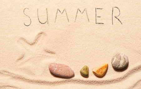 Mark of starfish, sea stones and summer lettering drawn on sand. Summer beach background. View from aboveの写真素材