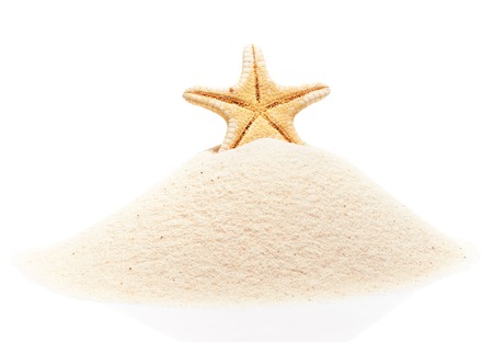 Starfish on pile of beach sand isolated on white backgroundの写真素材
