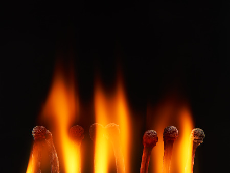 Set of eight burning wooden matches, isolated on black backgroundの写真素材