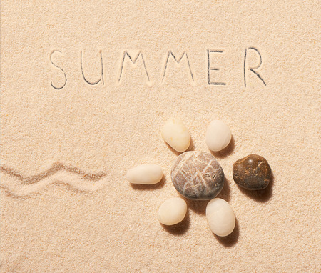 Turtle made of sea stones with mark of tail and summer lettering drawn on sand. Summer beach background. View from aboveの写真素材