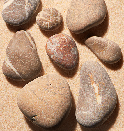 Close up of sea stones on sand. Summer beach background. View from aboveの写真素材