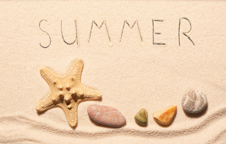 Starfish, sea stones and summer lettering drawn on sand. Summer beach background. View from aboveの写真素材
