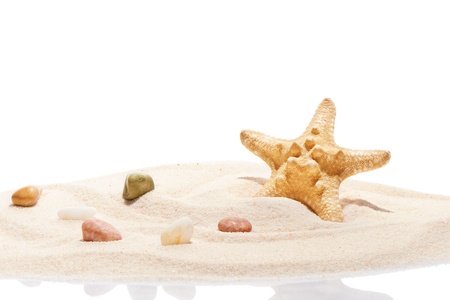 Starfish and sea stones on pile of beach sand isolated on white backgroundの写真素材