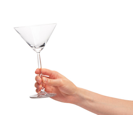 Close up of female hand holding empty clean transparent martini glass against white background.の写真素材