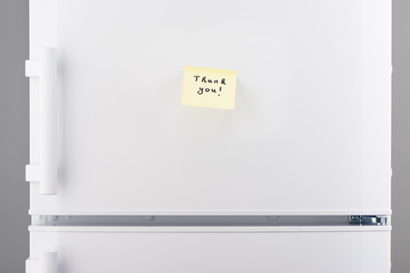Thank you note on light yellow sticky paper on white refrigerator doorの写真素材