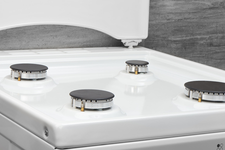 Close up of clean white kitchen gas stove on gray backgroundの写真素材