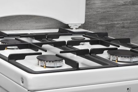 Close up of clean white kitchen gas stove on gray backgroundの写真素材