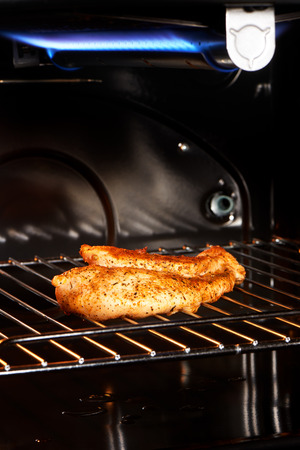 Close up of delicious golden chicken breast on gas grillの写真素材