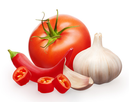 Whole fresh red tomato with green leaf, garlic with clove and cut chili pepper vegetables isolated on white backgroundの写真素材