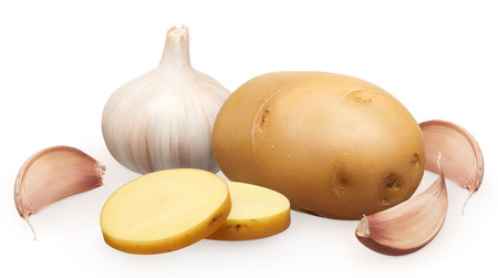 Whole fresh unpeeled potato with two chopped pieces and garlic with cloves isolated on white backgroundの写真素材