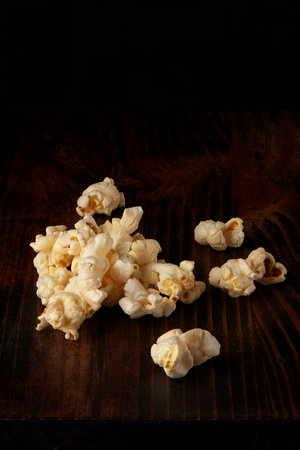 Popcorn pile on dark rustic wooden table and black backgroundの写真素材