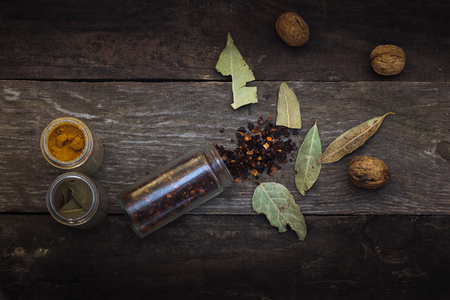 The photo shows the spices, which lie on a wooden table, decorated with composition further walnutsの写真素材
