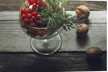 Kitchen Still Life. Filmed with berries and sea stones on a wooden background texture with green branches and walnutsの写真素材