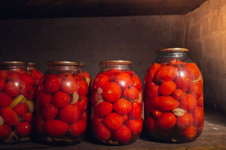 Photo of canned vegetables, in an old cellar with dim lighting, and with wooden shelvesの写真素材