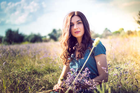 portrait of a woman in an autumn field with flowersの写真素材