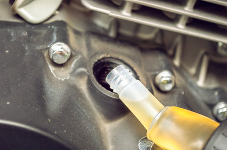 Replacing engine lubricant on a motorcycleの写真素材