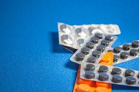 various pills in a package on a blue background, in a variety of positionsの写真素材