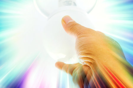 3d illustration of hand connecting to luminous bulb in science and technology conceptの写真素材