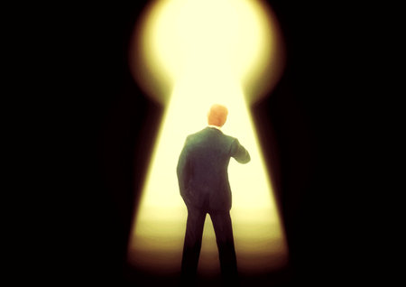 Silhouette of a businessman looking at a keyhole with light coming through itの写真素材