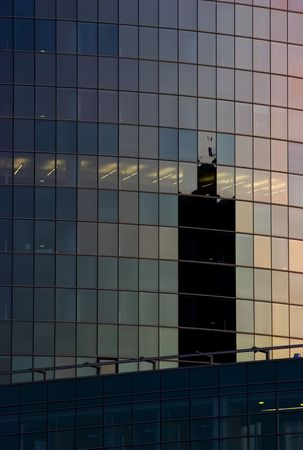 Corporate office building facade and reflection of other skyscraper in late eveningの写真素材