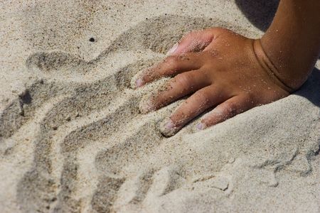 Kids hands playing with the sand on the beach. の写真素材