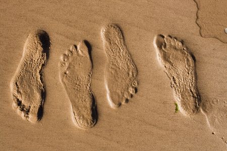 Footprints in wet sand at the Beachの写真素材