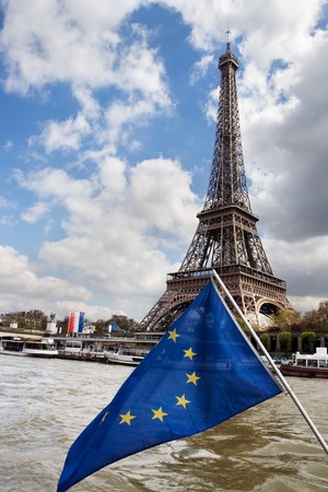 View at Eiffel tower across the Seine River from boat. European Union flag in front.の写真素材