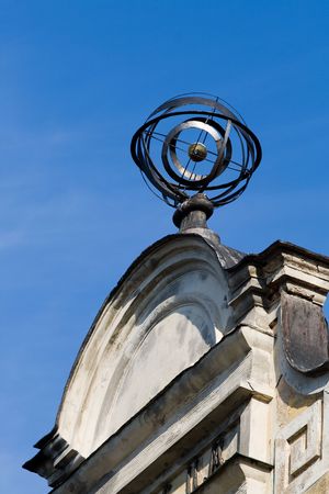 Old metalic weather vane against blue sky