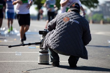 RIGA, LATVIA - MAY 23:  Professional REUTERS photographer in action at Riga International Marathon on May 23, 2010 in Riga.のeditorial素材
