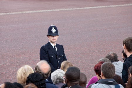 LONDON - JUNE 11: British policeman observes the crowd of spectators during the Trooping the Color ceremony in London, England on June 11, 2011. Ceremony is performed by regiments on the occasion of the Queen's Official Birthdayのeditorial素材
