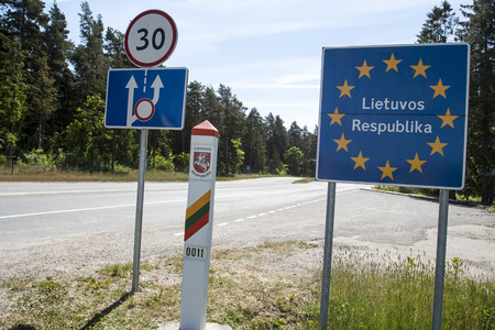 Lithuania country border sign between Latvia and Lithuania with coat of arms and flag のeditorial素材