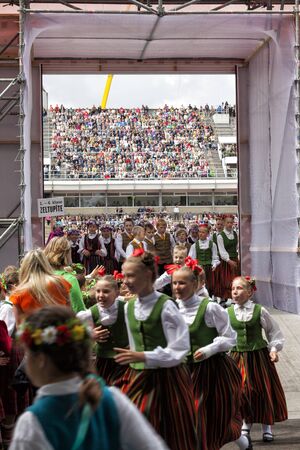 RIGA, LATVIA - JULY 11, 2015: Young Dancers in traditional costumes behind scene waiting for time to perform at the Grand Folk dance concert of Latvian Youth Song and Dance Festival in the Daugava Stadium.のeditorial素材