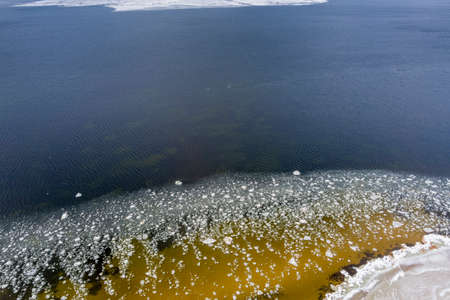 Ice blocks drifting around in a calm sea water creating interesting aerial patterns.の写真素材