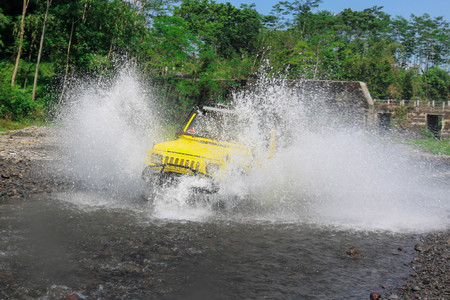 Extreme offroad car through water on the river so as to create sparks at Merapi Mountain Yogyakarta - Indonesia, Asiaの写真素材
