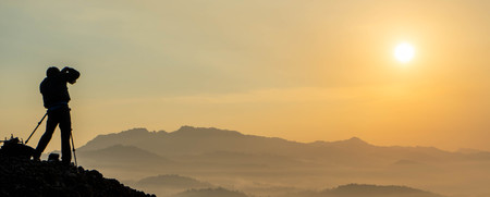 sunrise views in the summer that emerge from the hills in a village with photographer sillhouetteの写真素材