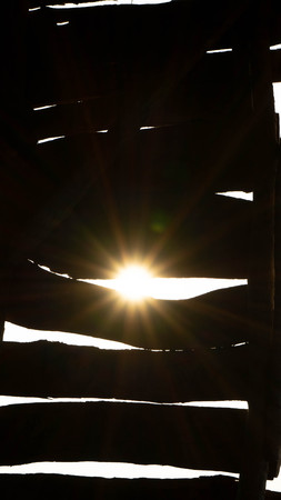 sunshine in the morning that goes through the crack of the wooden house windowの写真素材
