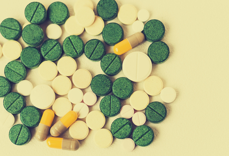 Medicine green, pink and yellow pills or capsulesの写真素材