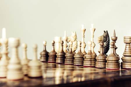 Wooden chess pieces on a chessboard, leadership concept on white backgroundの写真素材