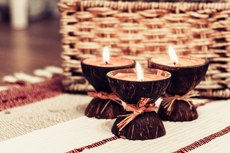 Burning spa aroma candles in coconut shell, cozy home interiorの写真素材