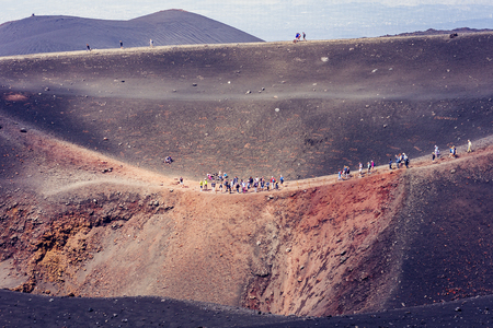 People walking on Mount Etna, active volcano on the east coast of Sicily, Italyの写真素材