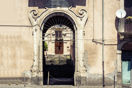 Arch, entrance of old houses, historical street of Catania, Sicily, Italyの写真素材