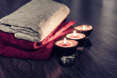 Burning spa aroma candles in coconut shell and towels, cozy interior backgroundの写真素材