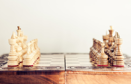 Wooden chess pieces on a chessboard, leadership concept on white background