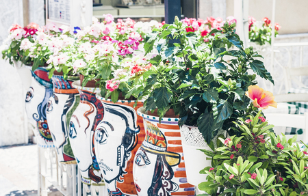Plant in clay pot on the historic street of Taormina, Sicily, Italy, traditional architectureの写真素材