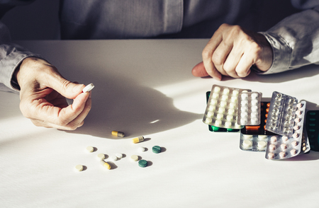 Medicine pills or capsules with old womanâs hands on white background with copy space. Blister packの写真素材