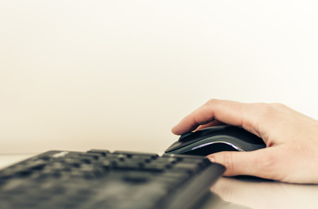 Close-up of hand woman using a mouse and typing on keyboard computer on glass table, business conceptの写真素材